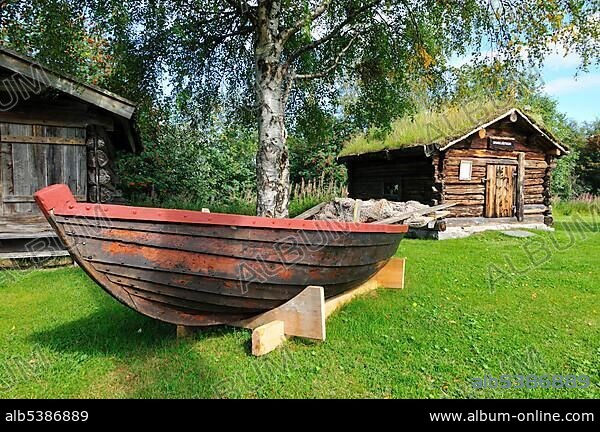 Fishing boat and traditional log-cabin in the Hede museum of local history, Haerjedalen, Sweden, Scandinavia, Europe.