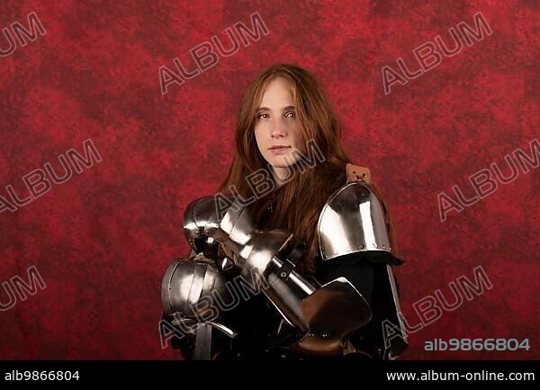 History of the Middle Ages. Portrait of a beautiful medieval female knight in armour on a red background.