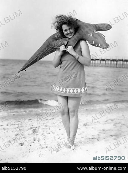 Swimwear, woman with swimsuit and inflatable crocodile on the beach, 1940s, Rügen, Baltic Sea, Germany, Europe.