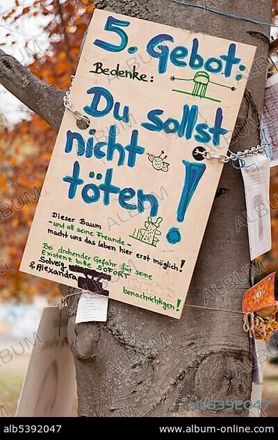 Protest poster, "5. Gebot, Du sollst nicht toeten", German for "5th Commandment, Thou shalt not kill" on an old tree against the Stuttgart 21 railway project, Schlossgarten, castle gardens, Stuttgart, Baden-Wuerttemberg, Germany, Europe.