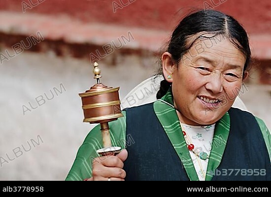 Tibetan woman with prayer wheel, Sera Monastery, Lhasa, Tibet, China, Asia.