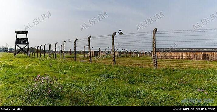 Auschwitz, Poland - 15 September, 2021: panorama view of barbed wire fence and guard tower and prisoner barracks at the Auschwitz concentration camp.