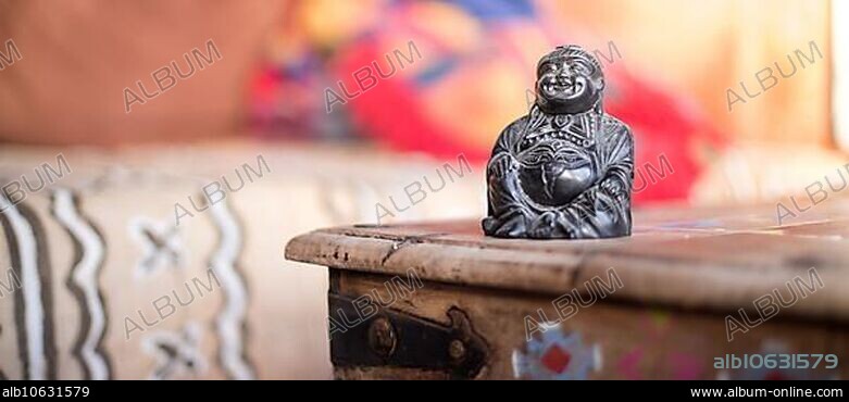 Feng shui: Buddha statue at on a table in the own living room.