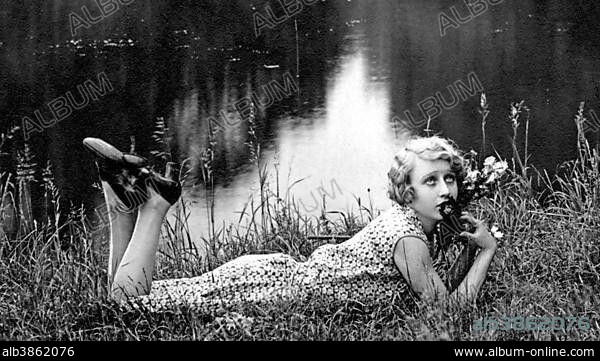 Fashion, Woman in summer dress in grass on a lake, 1920s, Germany, Europe.