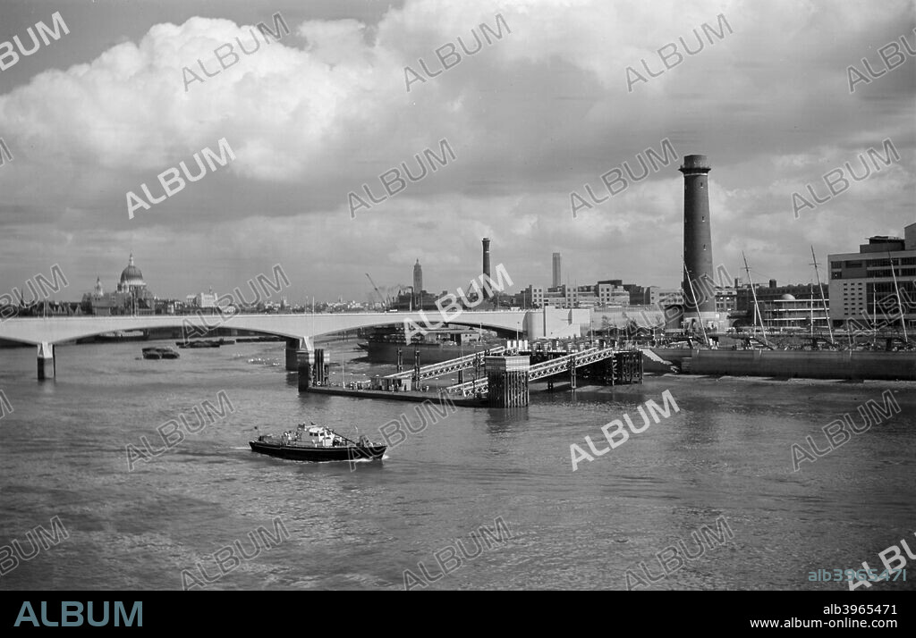 Festival Pier, Lambeth, London, c1945-1965. A view looking across the Thames towards the pier and shot tower beside Waterloo Bridge. The tower was built in 1826 and was incorporated into the development of the bank for the Festival of Britain in 1951. It was demolished afterwards.