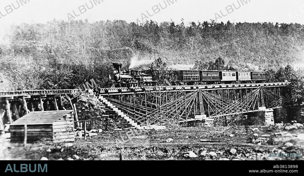 A B&O special train on one of the old Bollman Truss Bridges, at North Branch, Maryland.  This excursion train made a leisurely trip from Baltimore to Wheeling, West Virginia, and then returning, stopping at various points of interest for the benefit of the 40 artists and photographers aboard.  June, 1858.