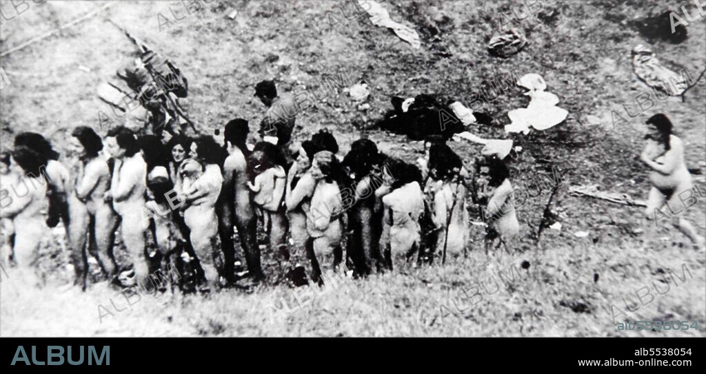 Holocaust, World War II: Naked Jewish women, some of whom are holding infants, wait in a line before their execution by German Sipo and SD, with the assistance of Ukrainian auxiliaries. 1942.