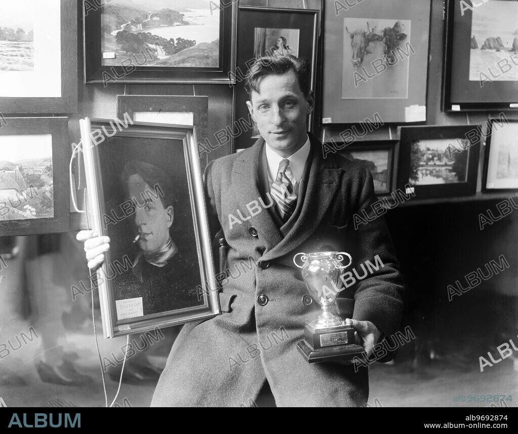 GWR arts and crafts exhibition at Paddington Station . Mr A H Start , Locomotive Fireman , of Cardiff , with the oil painting of himself and the trophy awarded to him . 31 March 1927.