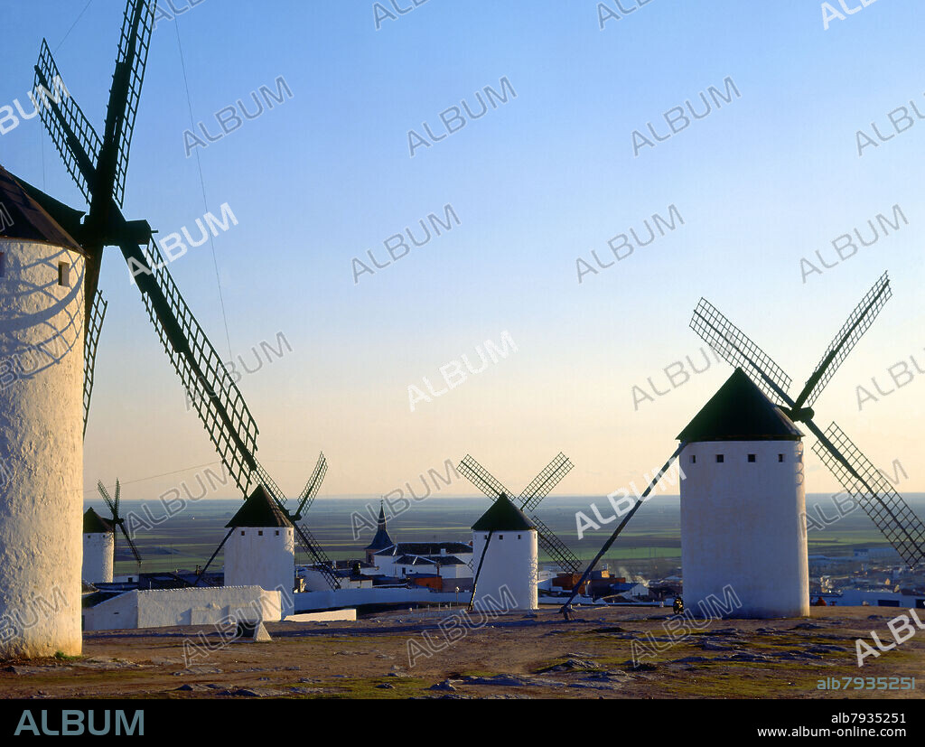 MOLINOS DE VIENTO AL ATARDECER CON LA LLANURA DE LA MANCHA DETRAS.