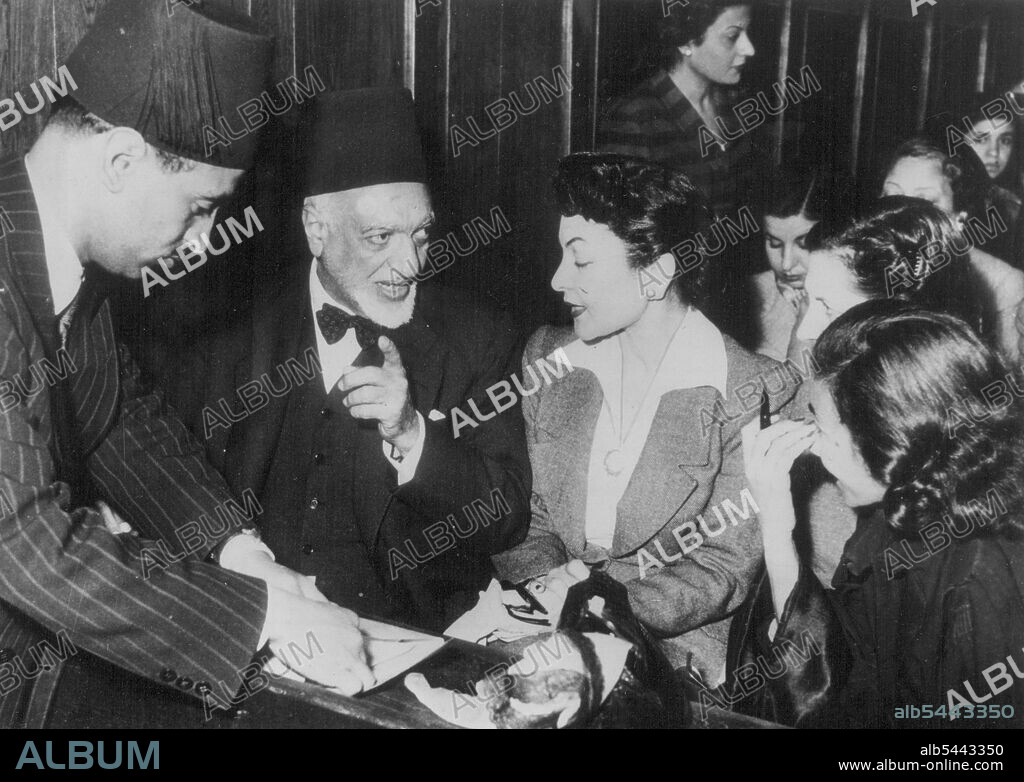 Egyptian Suffragette Leader On Trail Case Virtually Dismissed -- Doctor Doria Shafik, one of Egypt's foremost leaders of the emancipation of women movement, chats with her white-bearded father-in-law in court here. Her father-in-law was one of the six lawyers who volunteered to defend her in the case brought by the Egypt Government, who charged her with inciting revolt and leading a suffragette demonstration to Parliament House on February 19th to demand political rights for women. The Abdin District judge virtually dismissed the case when he postponed it indefinitely. French educated Doctor Shafik, one of Egypt's best-dressed women, is leader of the Ben El-Nil Union - Daughter of the Nile Movement. Her trial created great interest in Cairo. April 13, 1951.
