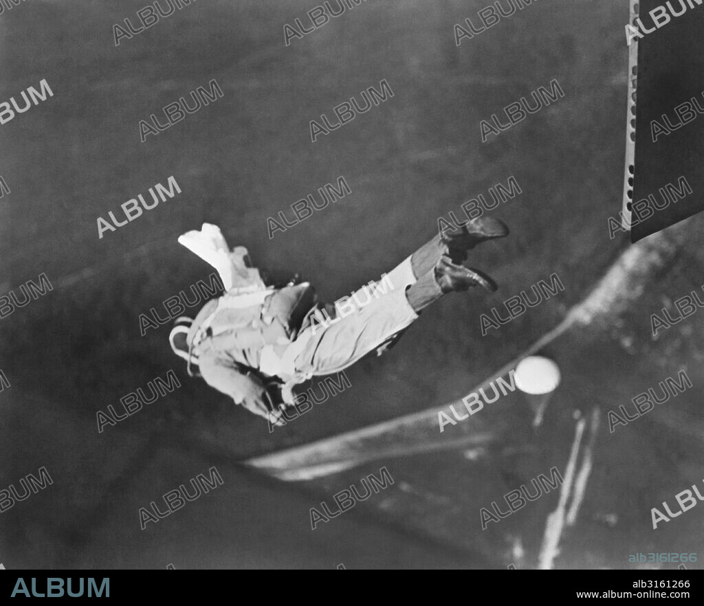 Lakehurst, New Jersey:  SEptember 17, 1942 A student parachute rigger at the Lakehurst Naval Air Station takes his final exam by jumping in a 'chute he packed himself. His pilot parachute is just starting to open and it's happy landings ahead.