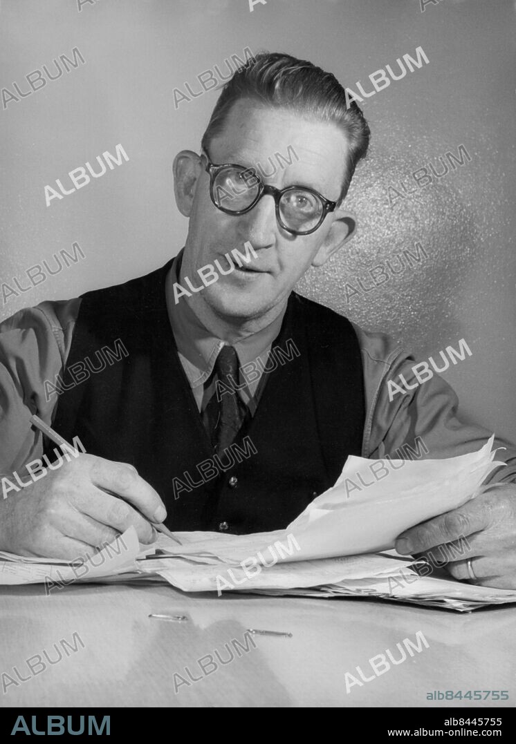 1958-02.. Orig. bildtext... En av basarna i VM-kommiten är Rolf Eriksson, som också är sekreterare i Bohusläns fotbollsförbund, ses här ifärd med det digra kontorsarbetet som uppstått med anledning av VM-matchen. Anm. VM i fotboll 1958 Blicken Öron Väst och slips CD314 persons: ROLF ERIKSSON sites: SVERIGE.