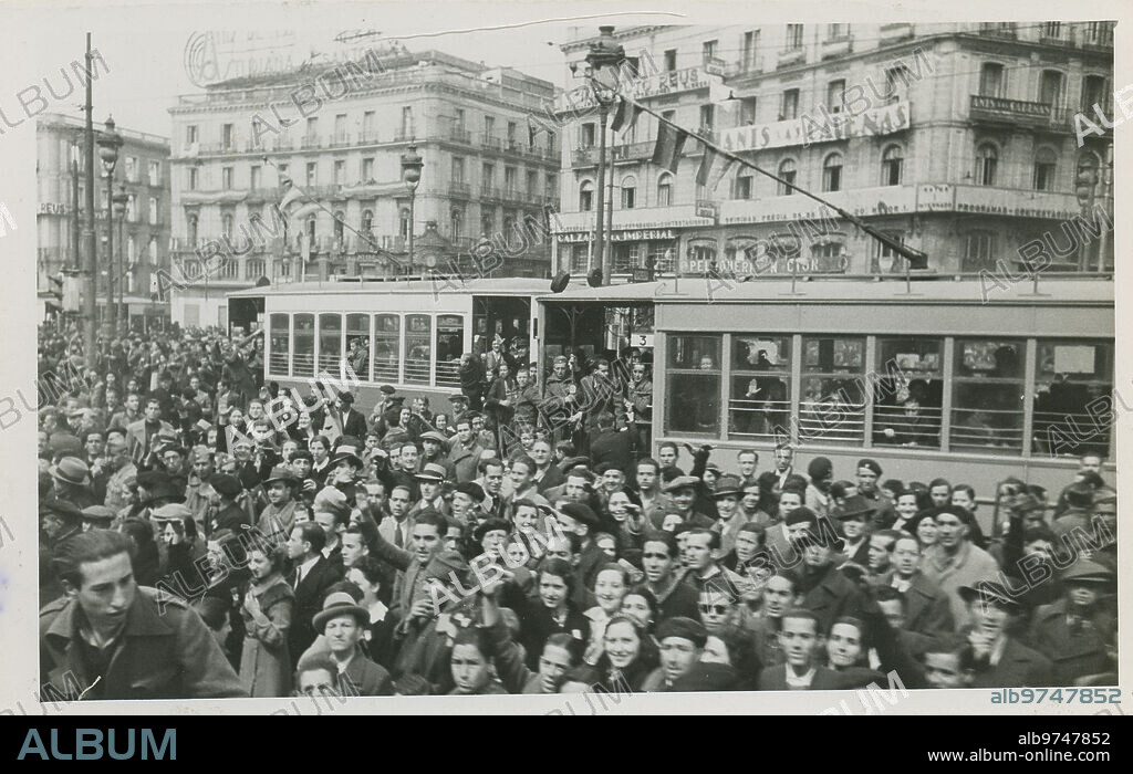 Madrid, 28/03/1939. Guerra Civil Española. La Puerta del Sol el día de la liberación de Madrid por el ejército nacional. La gente reunida en la Puerta del Sol cerca de un tranvía festejando la liberación de la ciudad.
