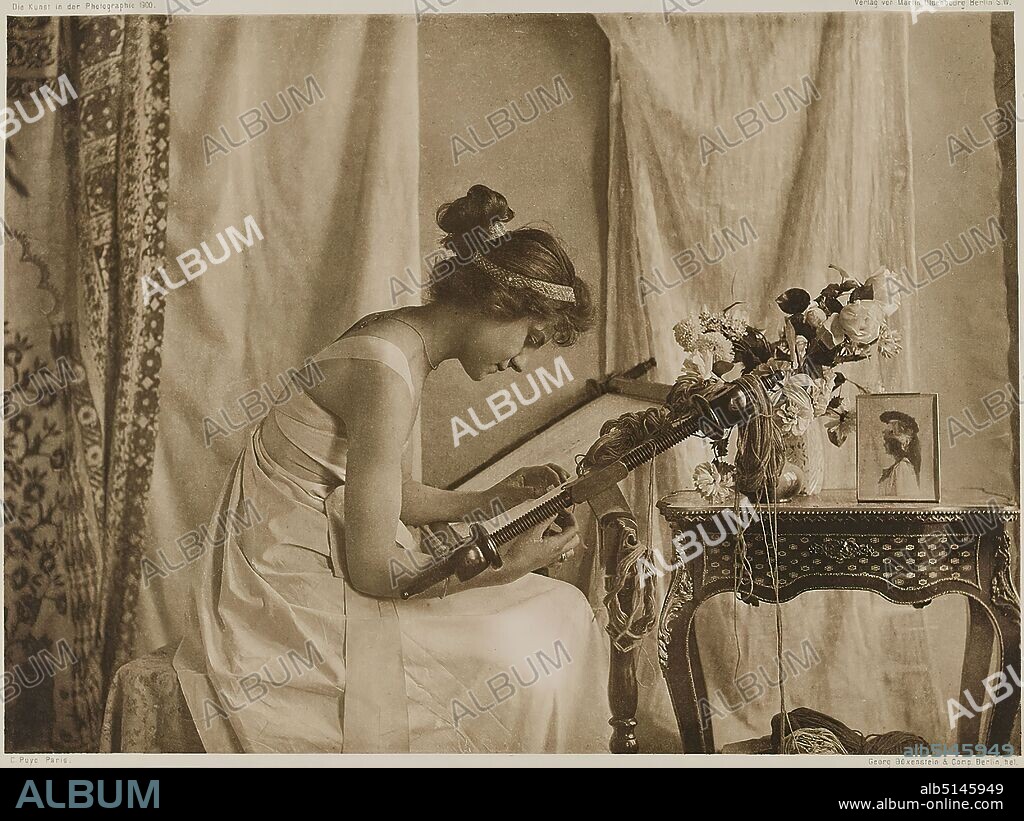 Emile Joachim Constant Puyo, Martin Oldenbourg, Büxenstein & Company, Young lady with embroidery frame, paper, heliogravure, image size: height: 22.90 cm; width: 16.60 cm, inscribed: recto: engraved below and above the image: top left: Die Kunst der Photographie 1900, top right: Verlag von Martin Oldenbourg, Berlin S. W, lower left: C. Puyo Paris, lower right: Georg Büxenstein & Comp. Berlin hel.; lower right on the cardboard in white ink: C. Puyo, Paris, K. Ph. 00, stamp: verso lower right on the cardboard: artistic photography, staged photography, woman, fashion, clothing, handicrafts, needlework, interior, seated figure, profile (side view), crochet, knit, embroider, specific poses, gestures, facial expressions, cut flowers, bouquet, containers, pictorialism, heliogravure from the magazine Die Kunst in der Photographie, Berlin 1900.