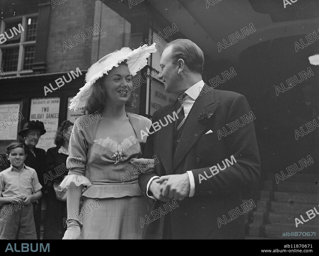 Greta Gynt weds Mr Noel Holland. Screen star Greta Gynt, 31 year old blonde Norwegian actress, was married to Mr Noel Holland, London business man at Caxton Hall. Miss Gynt wore a wedding dress of pale grey moire with trimmings of white broderie anglaise. Her large picture hat-moire on top with a white feather, she calls Indescribable . Picture shows : "Her leading man" - Greta smiles beneath her picture hat, as she leaves with her groom, after today's ceremony at Caxton Hall. 22 July 1948.