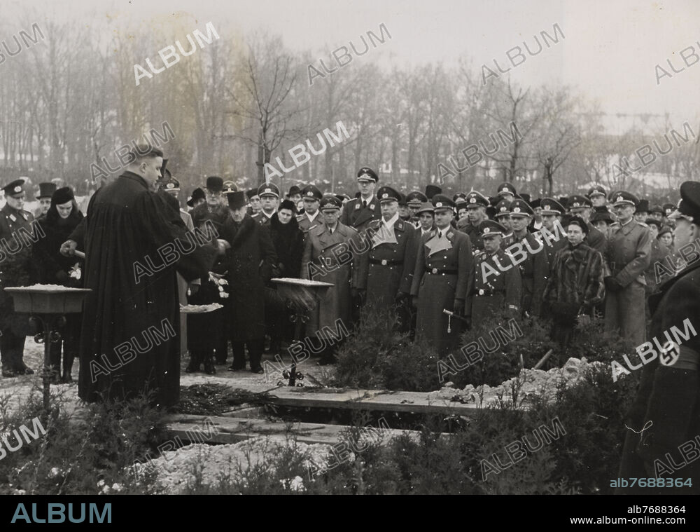 Beisetzung des DRK - Funktionärs Generalhauptführer Major Blumberg auf dem Goethe-Friedhof in Potsdam - Babelsberg, Angehörige des Verstorbenen und DRK - Funktionäre am offenen Grab während der Ansprache des Pfarrers. 3.v.r. der geschäftsführende Präsident des DRK Ernst Robert Grawitz.
- Februar 1942

OT: Beisetzung von DRK-GHF Major Blumberg (61 Jahre) Chef des Amtes II / Personalamt, starb am 5.2.1942 nach längerer Krankheit.

Zensurvermerk: gesperrt.