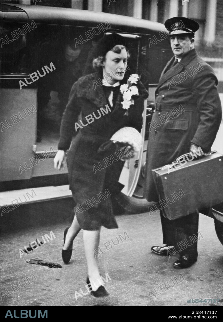 Orig. bildtext... MISS MARGARET GEDDES MARRIED QUIETLY TO PRINCE LUDWIG OF HESSE IN LONDON. Miss Margaret Geddes, daughter of Sir Aukland Geddes, left her home in Kensington for St. Peter's Church, Eaton Square, London, where she was married quietly to Prince Ludwig of Hesse, brother and successor of the Grand Duke of Hesse, who was killed with his family in the Osten air crash. The wedding was previously postponed owing to the deaths of Prince Ludwig's father, the late Grand Duke, and Sir Eric Geddes, uncle of the bride. Grand Duke George, his wife, mother and two sons were killed when the Sabena plane in which they were flying to London for the wedding, crashed near Ostend after striking a chimney in thick fog. Six others - passengers and crew - were also killed. Photo shows: The bride, Miss Margaret Geddes, drops her gloves as she leaves home for the Church. Anm. Chaufförer Resväskor Bråttom CD490 persons: MARGARET GEDDES sites: LONDON;STORBRITANNIEN.