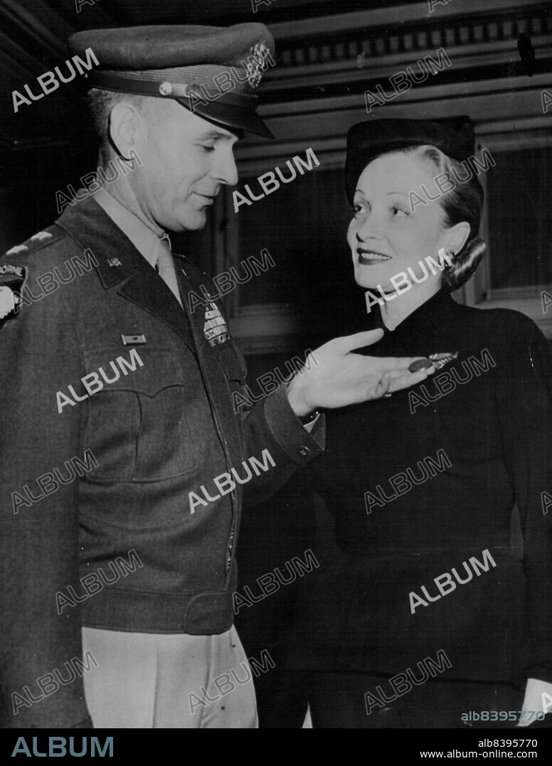 Marlene Honored For War Work -- Actress Marlene Dietrich Smiles as Maj. Gen. Maxwell D. Taylor, superintendent of the U.S. Military Academy at West point, Admires Medal for Freedom he pinned on her for her work in Entertaining Troops overseas during the War. Award Ceremony took Place in Cullum Memorial Hall at West Point, Nov. 18. November 19, 1947. (Photo by Associated Press Photo).