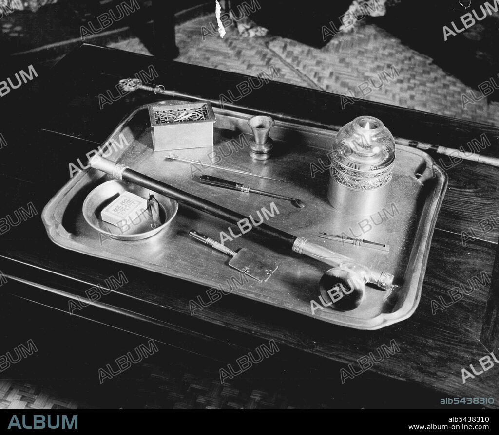 The Technique And Practice Of Opium Smoking -- The smoker's paraphernalia; A tray containing pipe, matches, a small slate with a handle on which the pellet of opium is rolled, tweezers, lamp, opium container, a long pin to use as a pipe cleaner. Sometimes these outfits are made of very fine and beautifully worked materials. February 27, 1952. (Photo by Hedda Morrison, Camera Press).;The Technique And Practice Of Opium Smoking -- The smoker's paraphernalia; A tray containing pipe, matches, a smal.