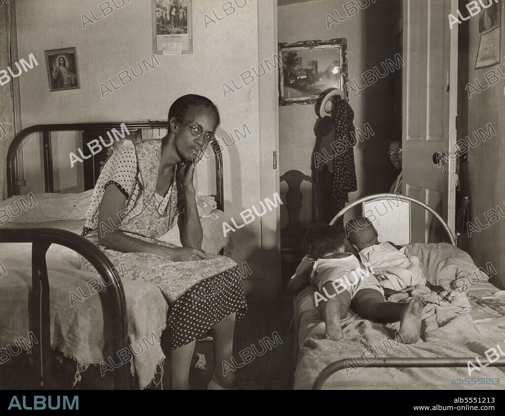 GORDON PARKS. Washington, D.C. Mrs. Ella Watson, who has been a government charwoman for twenty-six years, with three of the five children she supports on her salary of one thousand eighty dollars per year.