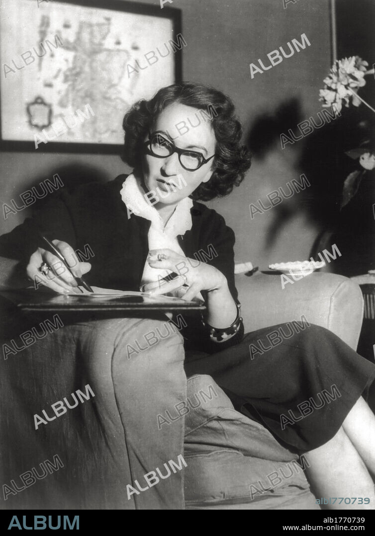 The writer Alba de Céspedes at work. The writer Alba de Céspedes y Bertini photographed while taking notes sitting in an armchair. 1950s.