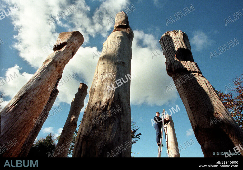 One young woman inspecting Eighteen Thousand Tides a sculpture by David Nash of old seafront groynes,.