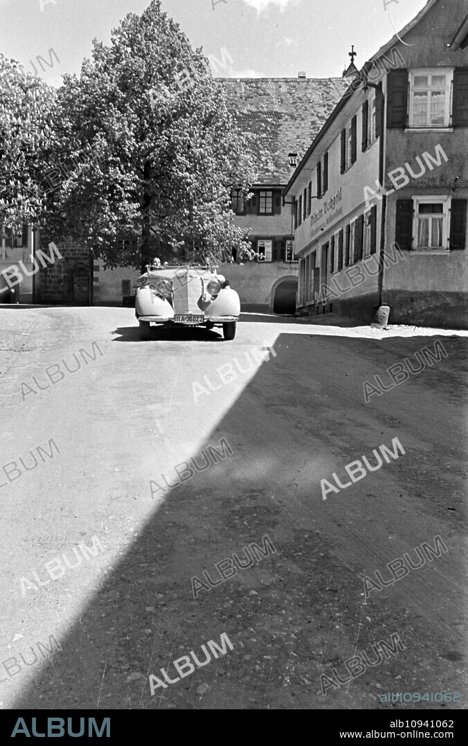 Travellers driving through the town Alpirsbach in the Black Forest, Germany 1930s.