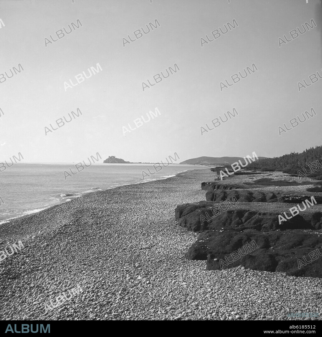 VISTA DE LA PLAYA PEDREGOSA CON EL PUEBLO Y EL CASTILLO AL FONDO - FOTOGRAFIA EN BLANCO Y NEGRO - AÑOS 50.