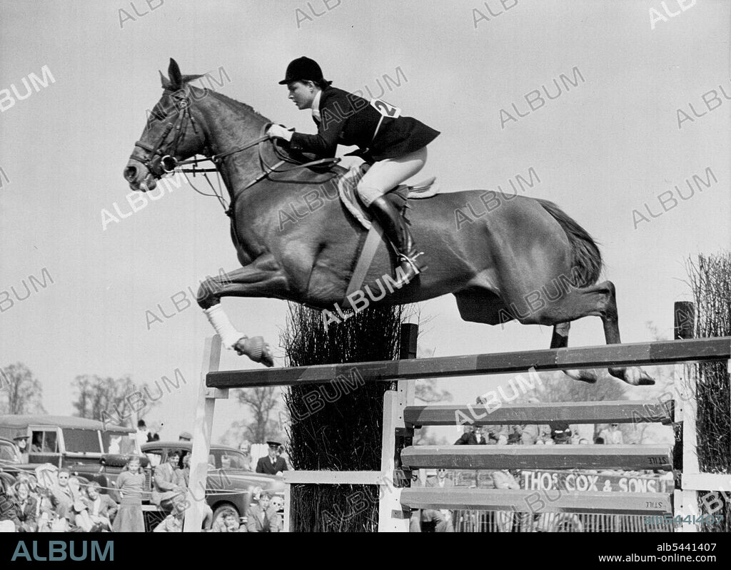 Perfect Teamwork -- A fine action shot of perfect teamwork as champion horsewoman Pat Smythe and her magnificent horse "Prince Hal" take a jump in their characteristic easy perfect style, whilst competing in the recent Beaufort Hunt jumping show at Badminton. The two-day jumping show of the Beaufort Hunt took place at Badminton on Friday and Saturday April 22nd, and 23rd. among the competitors at this event was Britain's champion show jumper Miss Pat Smythe, who together with her equally famous horse "Prince Hall", is a familiar figure at horse shows all over the world. April 23, 1955. (Photo by Fox photos).