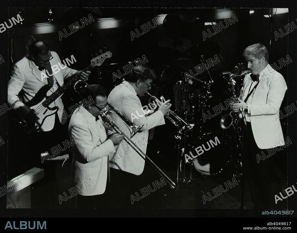 Bob Gill (bass guitar), Frank Brierley (trombone), Ian Royle (trumpet) and Stan Robinson (tenor saxophone) playing at the Forum Theatre, Hatfield, Hertfordshire, 1984.