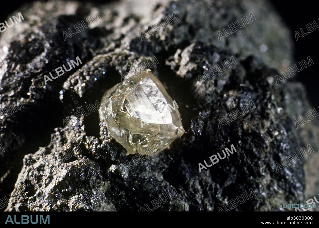 Diamond, composed of pure carbon, is the hardest mineral known, and also the most popular gemstone. It occurs in a unique rock known as kimberlite that was created at great depths and high temperature and pressure. Diamond also occurs in streams and offshore deposits, when the crystals have weathered out of their host rocks and transported by water. The most characteristic shape of a diamond crystal is the octahedron. Such crystals are usually small and scattered within their host rock. Matrix specimens, such as this one from South African, are very rare because diamond recovery is a large scale mass-production operation and the crushed rock is processed by machines.