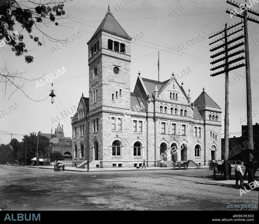 United States Post Office in front of the Winona Opera House, with the Winona Courthouse tower in the background, Winona, Minnesota, between 1892 and 1899.
