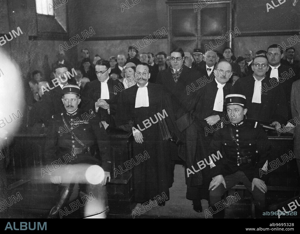 Grandson of great painter charged with faking masterpieces . Hundreds of faked masterpieces are concerned in the trial at Fontainebleau , France of Jean Charles Millet , grandson of the famous painter . With Millet in the dock is Paul Cazot , a retired house painter and his wife Madame Cazot . The charges are of selling pictures bearing the forged signature of Millet ' s grandfather and other famous 19th century masters. Photo shows ; Paul Cazot ( extreme left with moustache ) , Madame Cazot ( centre ) and Jean Charles Millet ( tall figure wearing spectacles ) in court at Fontainebleau . 29 January 1935.