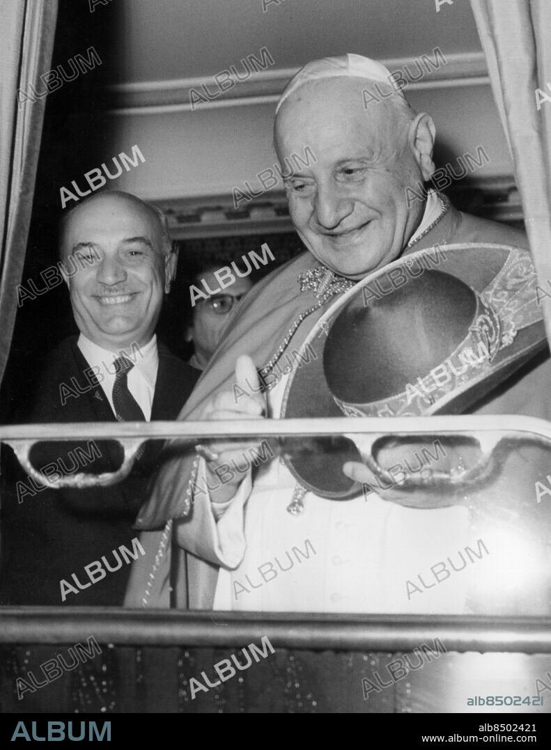 Orig. bildtext...THE LAST TIME IT WAS USED THE PAPAL TRAIN it was in 1863, when the Pope Pius IX went to Velletri, a little country near Rome. Today the Saint Father John XXIII, early in the morning left the Vatican City, by train, to go to Loreta (near Ancona) and to Assisi. The Saint Father visited to the world famous christian sanctuaries to pray the Vergin before the beginning of the Ecumenical Council. The Pope travel is a great event: everywhere people applauded the Pope transit and great rejoings have welcome the Saint Father across the countries, touched by the papal train. Photo shows: The Pope with the President of the Council, mr. Fanfani, on the train at the Trastevere Station. 4.10-1962 Anm. Johannes XXIII, född Angelo Giuseppe Roncalli, 1881-1963, påve från 1958 till sin död. A Fanfani, 1908-1999, italiensk politiker, premiärminister i flera regeringar på 1950- och 1960-talen. Resenärer CD684 persons: AMINTORE FANFANI;JOHANNES XXIII sites: ROM;ITALIEN.
