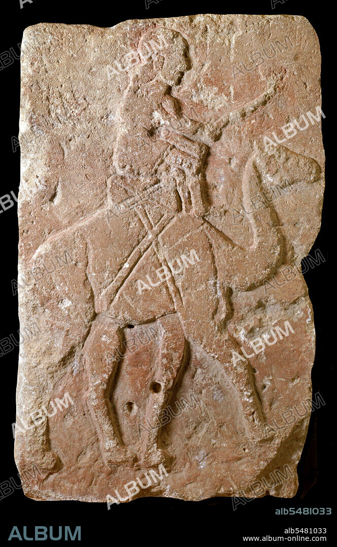 This bas-relief was excavated in northern Syria at the site of Tell Halaf, the capital of a small independent city-state known as Guzana, which was conquered by the Assyrians in the late 9th century BC. More than two hundred such stone reliefs (styled orthostats) decorated the facade of a temple-palace built in the 10th century BCE by a local ruler named Kapara. He reused the blocks from one or more pre-existing structures and carved an inscription in cuneiform on each one statings, 'Palace of Kapara, son of Hadianu'. The blocks were placed so that limestone ones painted red alternated with others of black basalt. In this image, a rider sits atop the hump of a dromedary camel, driving it on with a staff. Crossed leather or cloth bands fasten the saddle to the animal. The image represents an Arab caravan trader. The domestication of dromedaries shortly before the beginning of the first millenium BCE made the caravan trade possible. This relief from Tell Halaf may be the earliest representation of such a dromedary rider.