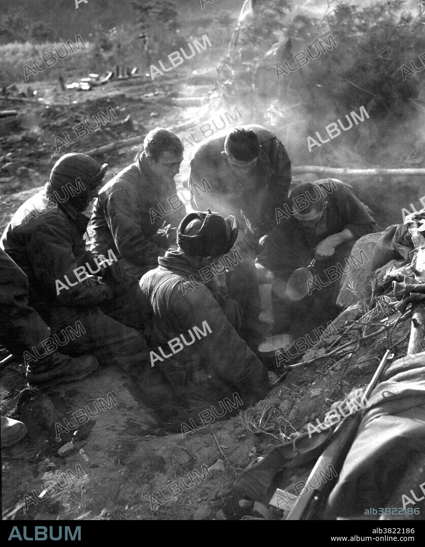 Captioned: "These men of the Heavy Mortar Company, 7th Infantry Regiment, go native, cooking rice in their foxhole in the Kagae-dong area, Korea." The 7th Infantry is a regiment in the United States Army. In its 200 year history it has participated in 12 wars, been awarded 76 campaign streamers, and 14 unit decorations. The regiment has served in more campaigns than any other infantry unit in the U.S. Army. Nicknamed the "Cottonbalers" from an incident that occurred during the Battle of New Orleans. A foxhole is a type of defensive position. A defensive fighting position (DFP) is a type of earthwork constructed in a military context, generally large enough to accommodate at least one person. Photograph credited to Private 1st Class Donald Dunbar, U.S. Army, December 7, 1950.
