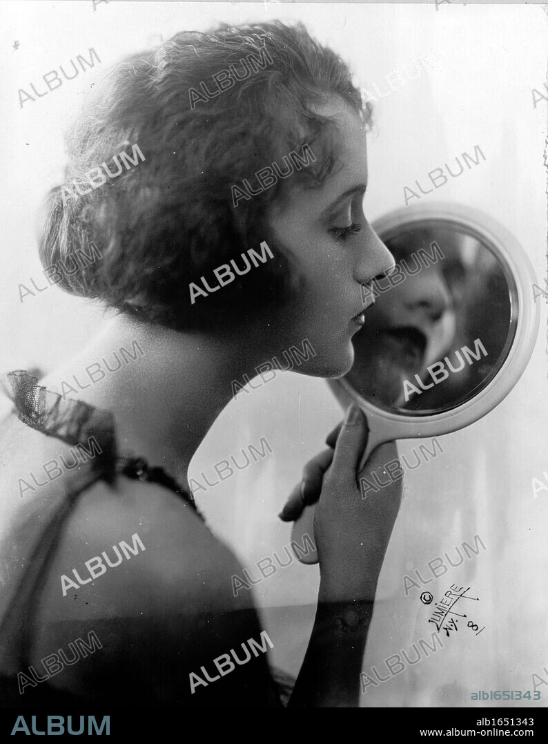 Constance Talmadge, American Silent Movie actress, looking into mirror 1921.
