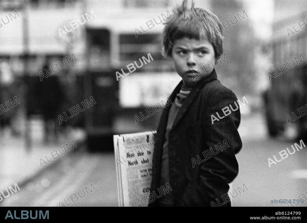 Journalisme : marchands de journaux. Petit garçon vendant des journaux à Dublin (Irlande). Août 1974.