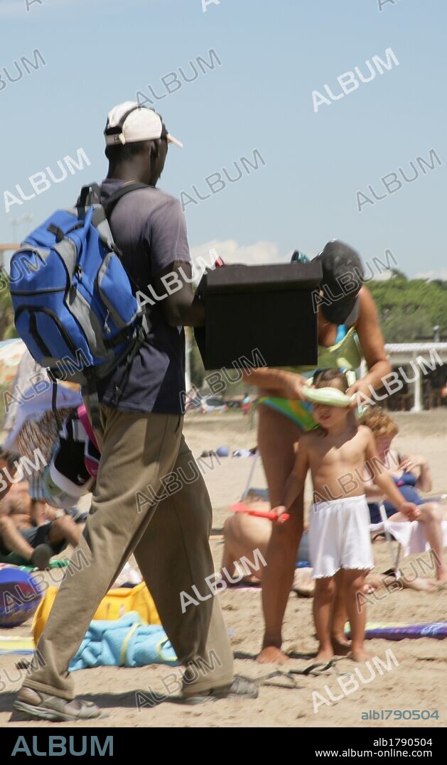 VENDEDOR AMBULANTE en la playa de la localidad. Castelldefels. Comarca del Baix Llobregat. Provincia de Barcelona. Cataluña.
