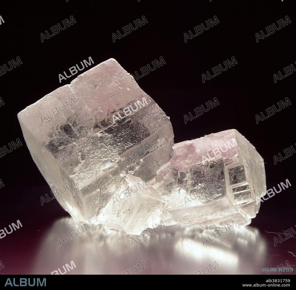 Cubic crystals of rock salt (known as halite) or naturally occurring sodium chloride (chemical formula NaCl). Rock salt is caused by the drying of bodies of salt water. It usually crystallizes in the form of cubes, and has perfect cleavage, the tendency to split along definite crystal planes. Rock salt is used in the chemical industry and as a preservative in the food industry.
