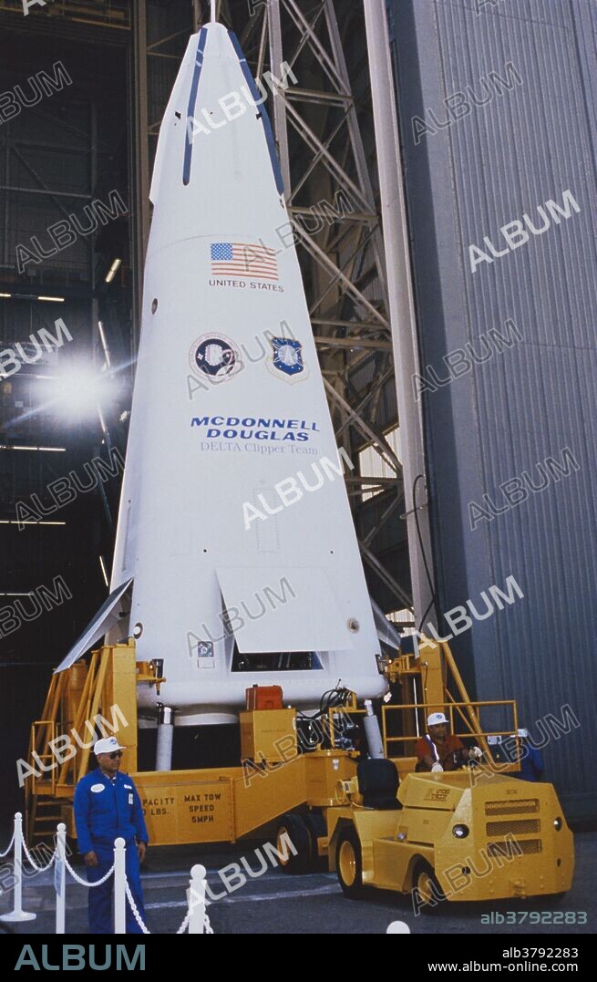 The Delta Clipper DC-X being rolled out from its check-out building.  This was the first vehicle in the Delta Clipper program.  The vehicle was envisioned as a reuseable single-stage rocket to provide a cheap and reliable way to get satellites into orbit.  The DC-X was one-third of the size of the final design.  The project is currently in limbo, after funding was cut in the mid-1990's.  During its initial flight, (8/18/93), the vehicle rose about 50 meters high, and maneuvered about 100 meters to one side whilst hovering.  It then landed vertically on its four retractable legs.