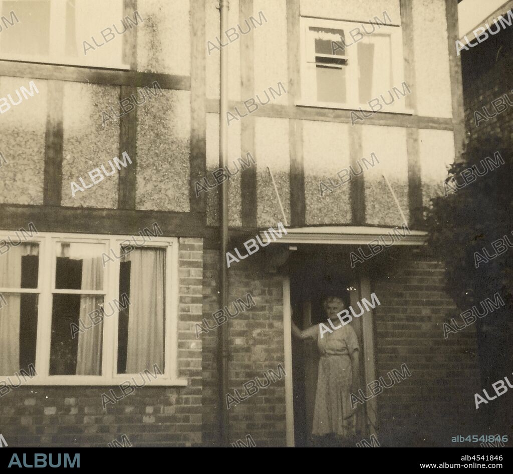 Photograph - Eileen Nevin Outside Family Home, Heston, Middlesex, England, circa 1950, Photograph of Eileen Nevin standing in the doorway of her home in Heston, Middlesex, England, circa 1950. It was amongst a selection of photographs sent to Australia by Eileen Nevin, mother of Eileen Leech after she, her husband James, and daughter Susan migrated to Australia in 1953 and also amongst those they brought back to England when they returned in 1956. It was this house the family.
