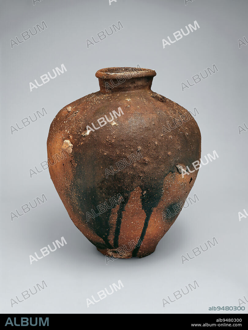 Storage jar, 15th century, Unknown Japanese, 17 7/8 × 14 1/2 × 14 3/4 in. (45.4 × 36.83 × 37.47 cm), Shigaraki ware; stoneware with natural ash glaze, Japan, 15th century, The town of Shigaraki, southeast of Kyoto, was one of Japans great pottery-making centers, producing huge numbers of large storage jars and sturdy mortars (vessels used for grinding seeds and spices). Shigaraki clay contains high levels of sand and the mineral feldsparimperfections that burst, or 'bloom,' in the kiln, giving the surface its characteristic roughness. This jar also has an unusually heavy deposit of natural glaze, the result of wood ash settling on the vessels shoulder, liquefying in the heat, and then running down the sides in dramatic, uneven drips.