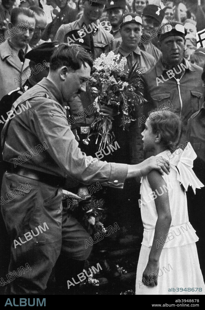 Adolf Hitler talking with a young girl during his election campaign, 1932. Hitler (1889-1945) finished second to Paul von Hindenburg in the 1932 German presidential election. In January 1933 Hindenburg reluctantly agreed to appoint him Chancellor. A print from Adolf Hitler. Bilder aus dem Leben des Führers, Hamburg: Cigaretten/Bilderdienst Hamburg/Bahrenfeld, 1936.
