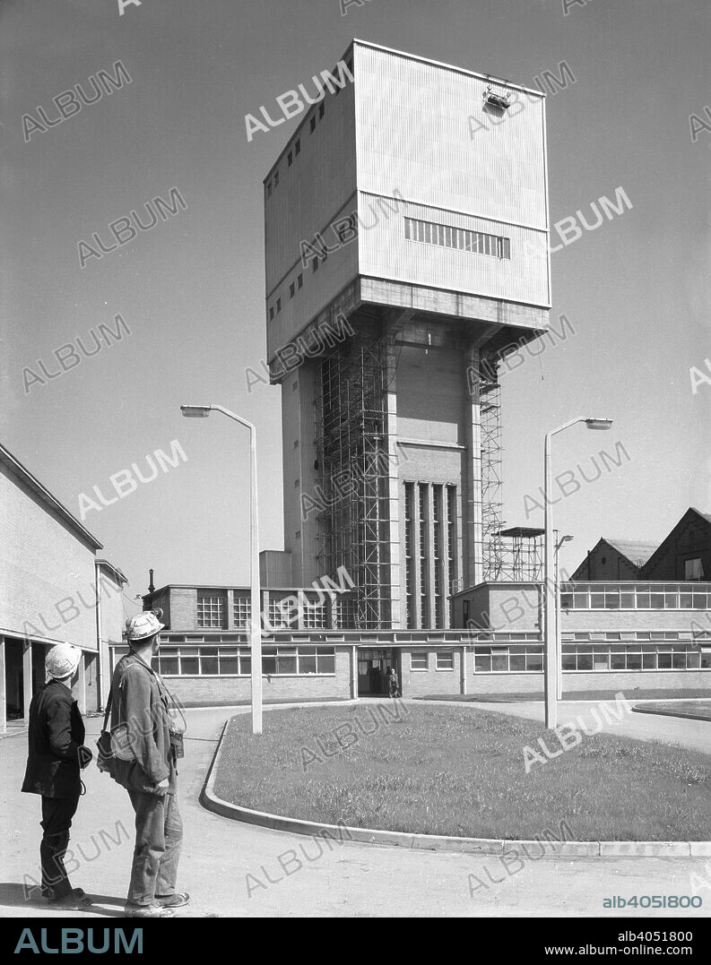 Killoch Colliery, Ayrshire, Scotland, 1960. Two miners look towards the new winding tower at Killoch Colliery in Ayrshire. The pit was sunk in the 1950s and although the mine closed in 1987, the site continued to be used for coal distribution.