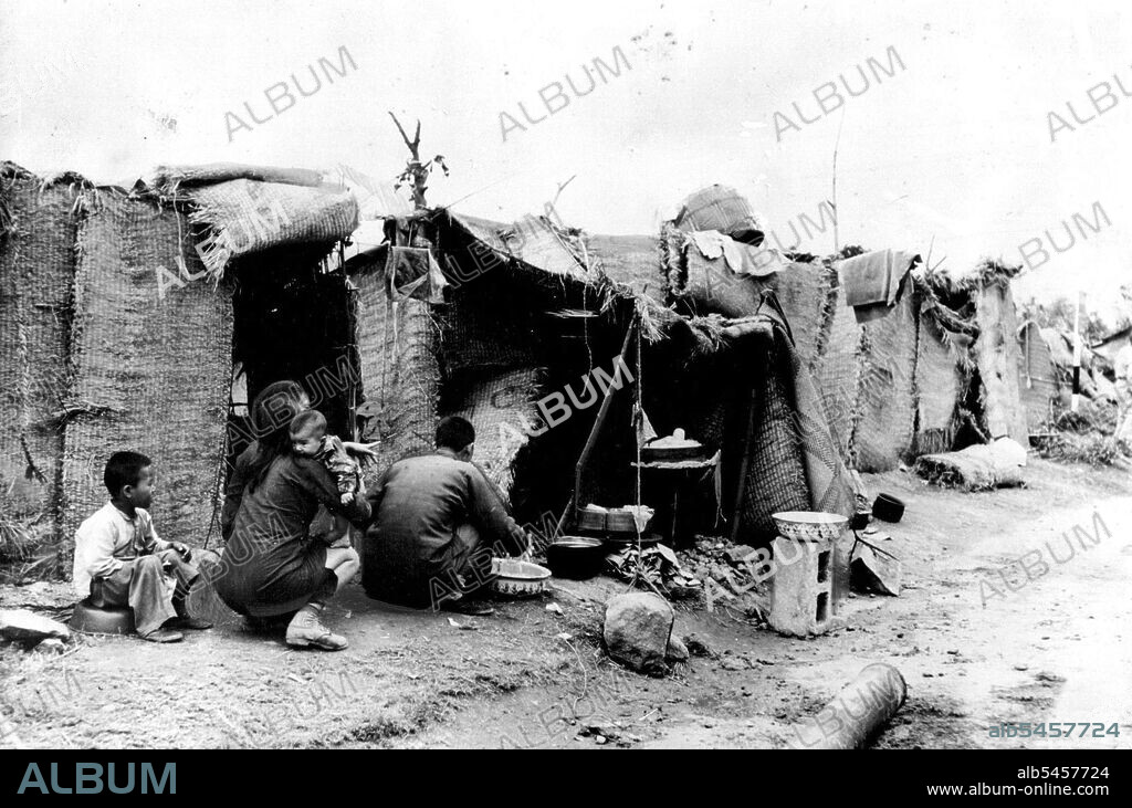 Hong Kong Refugee 'Overflow' Camp Illicit Entry Fears -- A refugee family outside a hastily thrown-up rattan shelter at the camp on the slopes of Mount Davis, Hong Kong.Chinese refugees, flooding into Hong Kong territory from Communist-held China, have established themselves in an 'overflow' camp on the site of the old Jubilee Fort on the slopes of Mount Davis.In ruined buildings and in squalid rattan huts they have gradually formed their own sparwling community on the cliffside. April 24, 1950. (Photo by Reuterphoto).