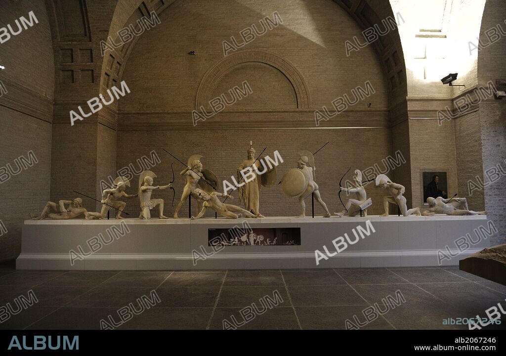 ARTE GRIEGO. GRECIA. Reconstrucción del grupo escultórico del frontón Oeste del Templo de Aegina. El original fechado hacia el 500 a. C. Guerreros troyanos y griegos junto a la diosa Atenea. Glyptothek. Munich. Alemania. Europa.