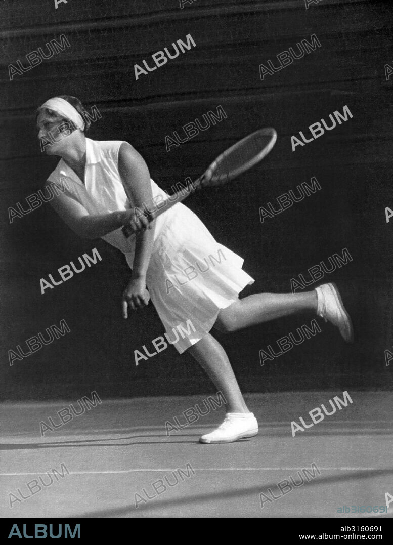 England:  c.  1927 British tennis player, Olympic gold medalist and Wimbledom champion Kathleen McKane Godfree returning a ball on the tennis court.