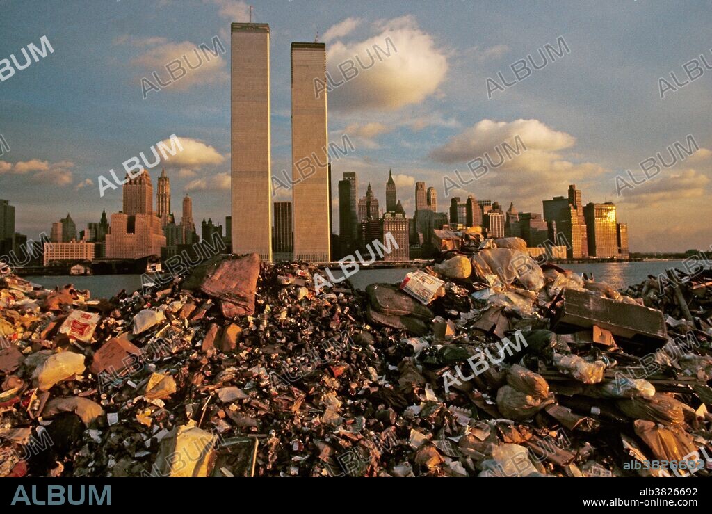 A garbage scow is pulled to a Great Kills landfill in Staten Island. View of New York and the newly completed World Trade Center towers in the background. Image taken in 1970.