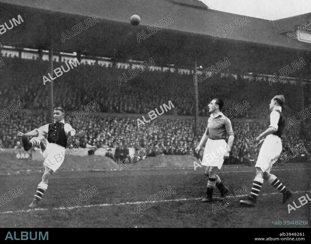 Acrobatics in a Arsenal v Chelsea match at Stamford Bridge, London, c1933-c1938. Arsenal captain Eddie Hapgood clears the ball watched by Chelsea's George Gibson (centre) and fellow Arsenal full back George Male. A print from Football Ambassador by E A (Eddie) Hapgood, Sporting Handbooks LTD, London, 1945.